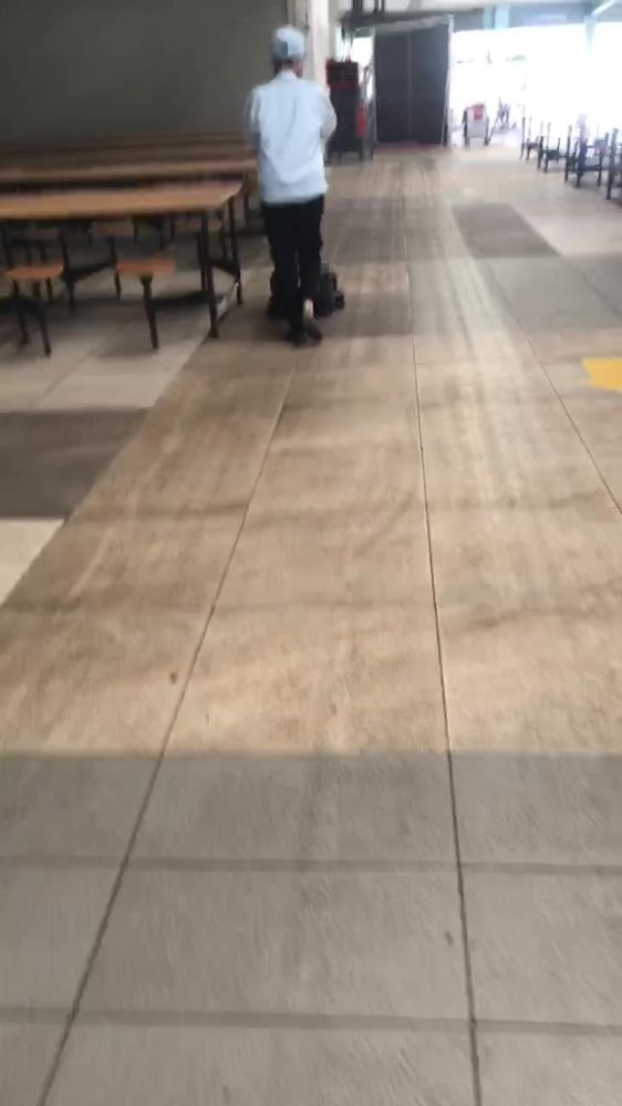 SH1 đi dọc dãy bàn ghế liền trong canteen